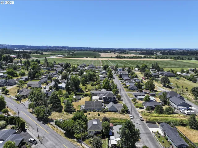 an aerial view of a city with lots of residential buildings and ocean view in back