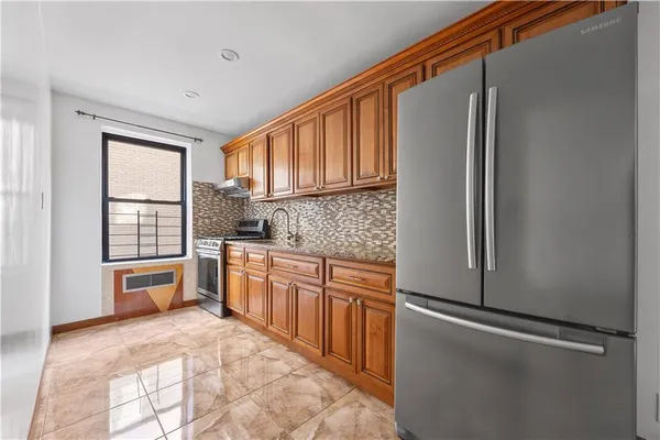 a kitchen with stainless steel appliances granite countertop a refrigerator and a sink