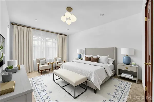 a bedroom with a large bed and a chandelier