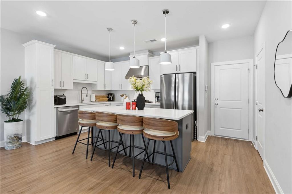 1324 Parc Bench Road Atlanta, GA 30316 - Photo 10 of 35 a kitchen with kitchen island a dining table chairs refrigerator and cabinets