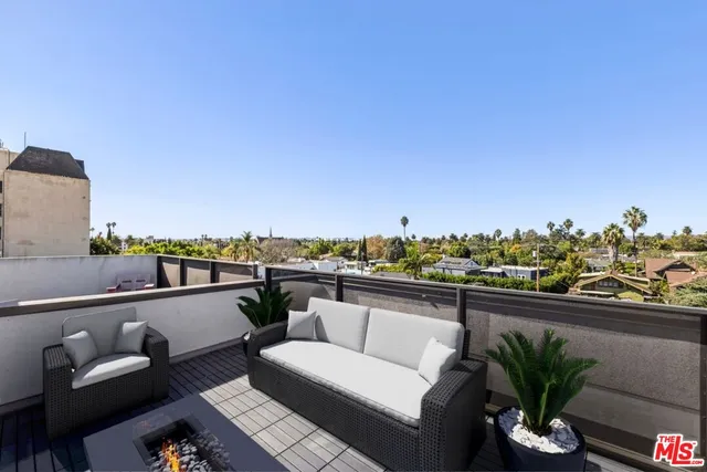 a view of a balcony with couch and chairs