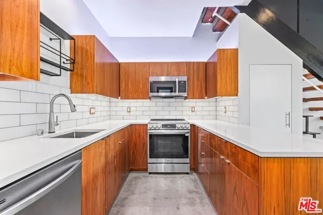 a kitchen with stainless steel appliances sink a stove and a microwave