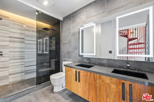 a bathroom with a granite countertop sink and a toilet