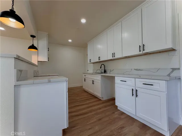 a kitchen with cabinets appliances and a wooden floor