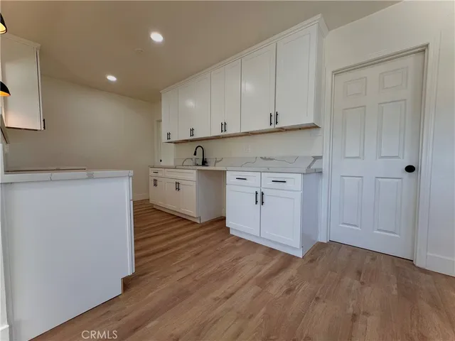 a view of a kitchen with wooden floor and electronic appliances