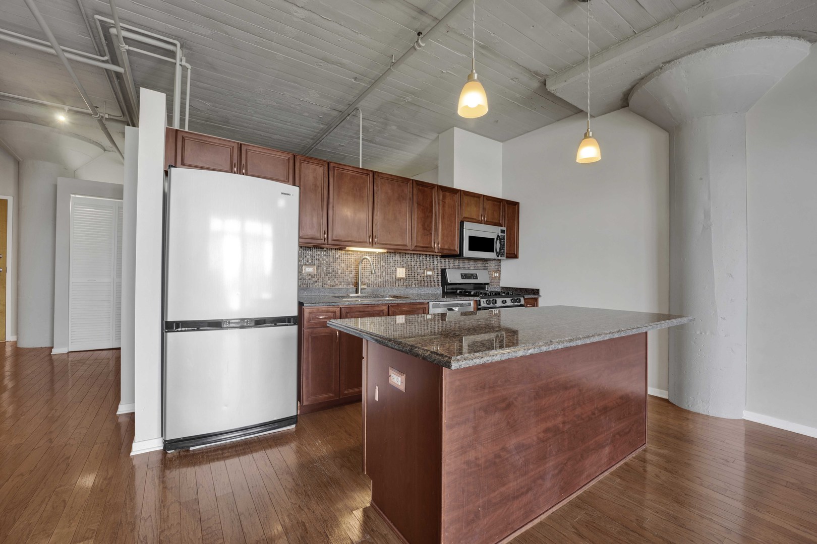 1525 South Sangamon Street, Unit 504 Chicago, IL 60608 - Photo 4 of 32 a kitchen with a refrigerator a microwave a sink and a stove