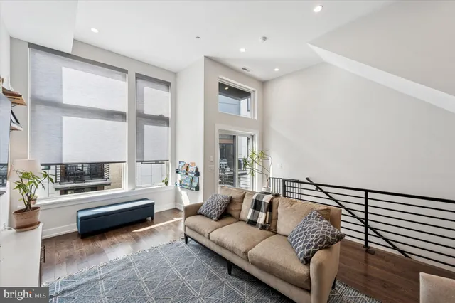 a kitchen with stainless steel appliances a stove a sink a refrigerator and a dining table with wooden floor