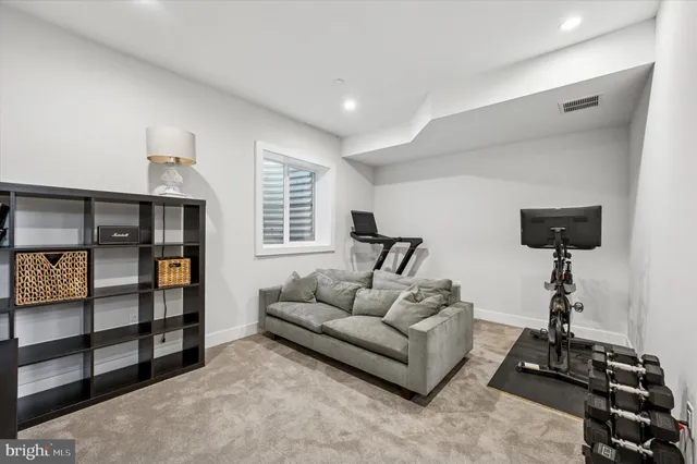a living room with furniture gym equipment and a chandelier