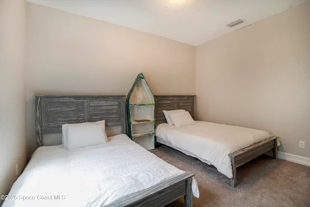 a bedroom with two beds and window