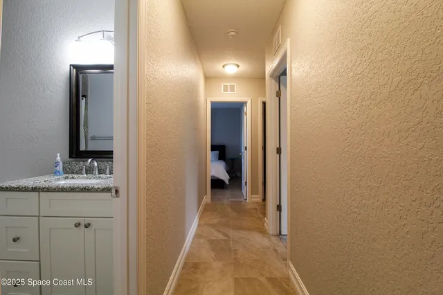 a en suite bathroom with a granite countertop sink and a mirror