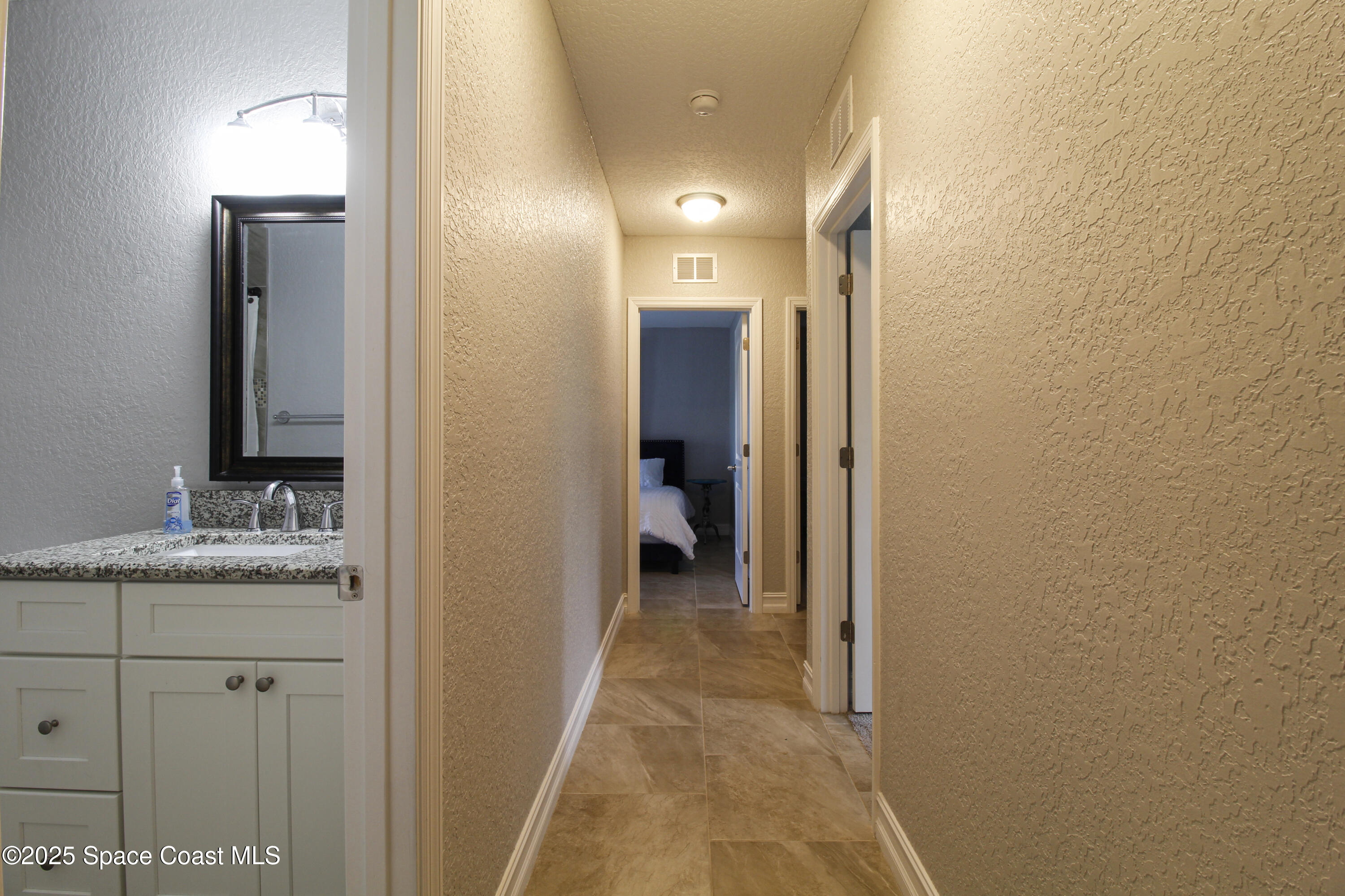 827 Glenmore Circle Melbourne, FL 32901 - Photo 13 of 30 a en suite bathroom with a granite countertop sink and a mirror