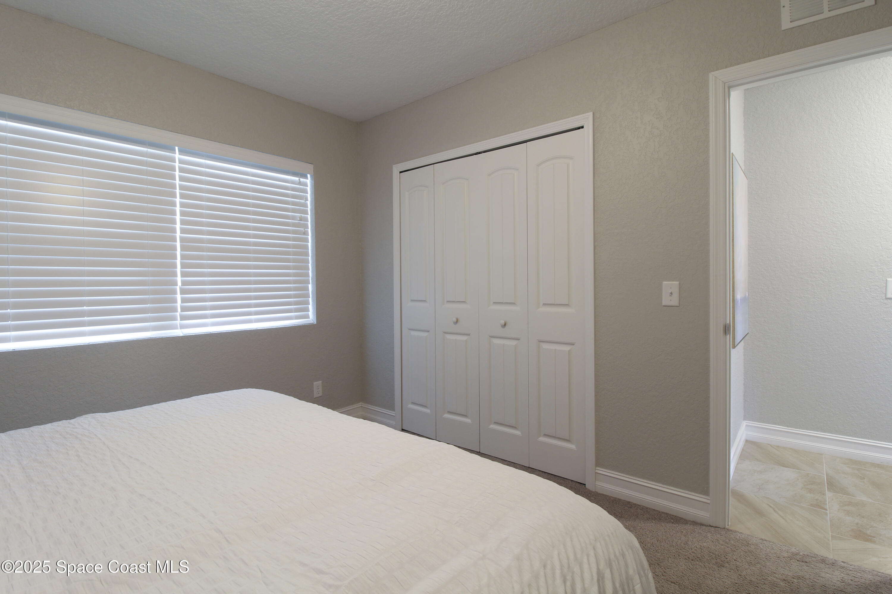 827 Glenmore Circle Melbourne, FL 32901 - Photo 16 of 30 a bedroom with a bed and a window