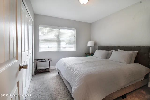 a bed room with a bed and a chair