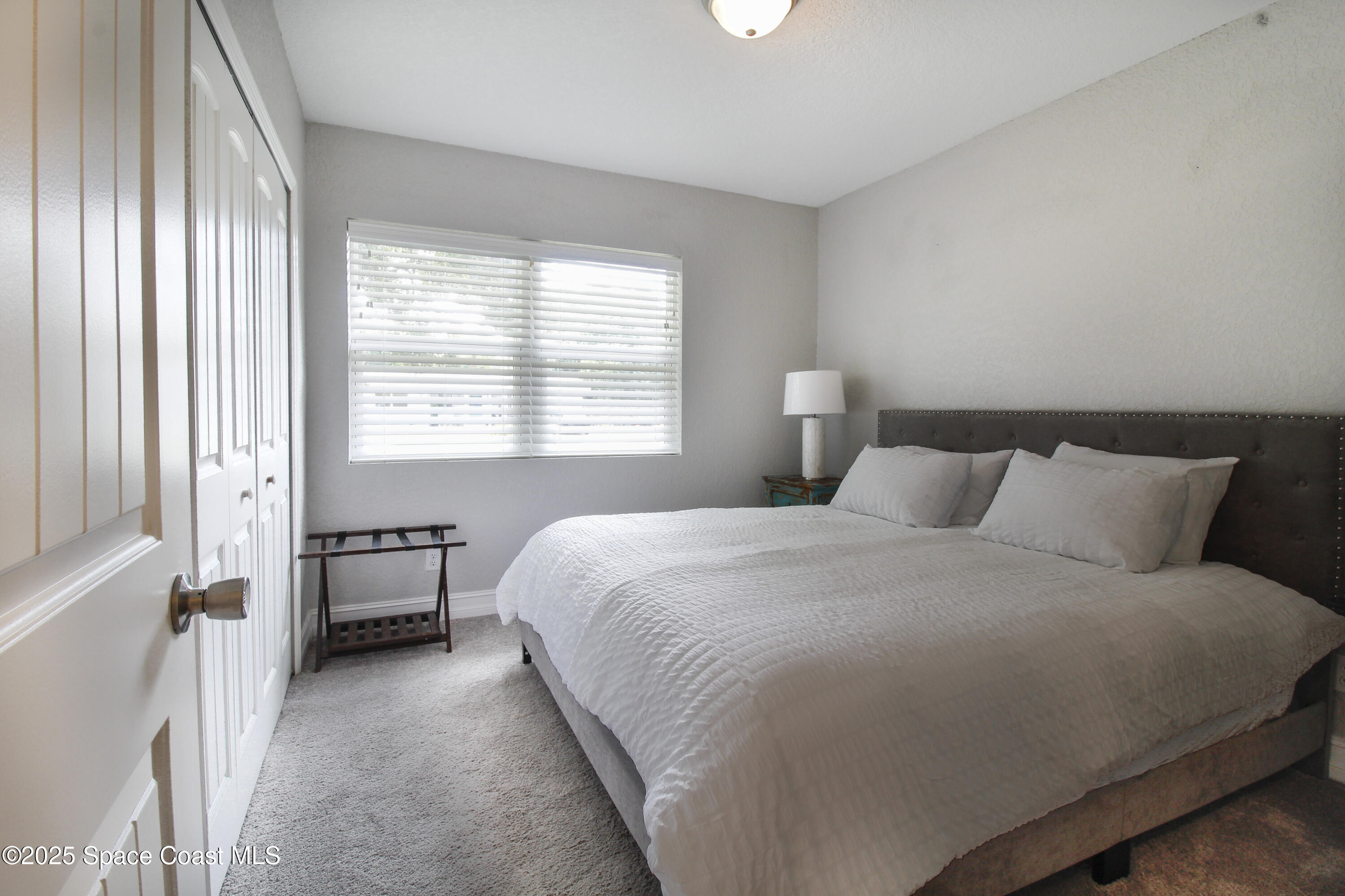 827 Glenmore Circle Melbourne, FL 32901 - Photo 17 of 30 a bed room with a bed and a chair