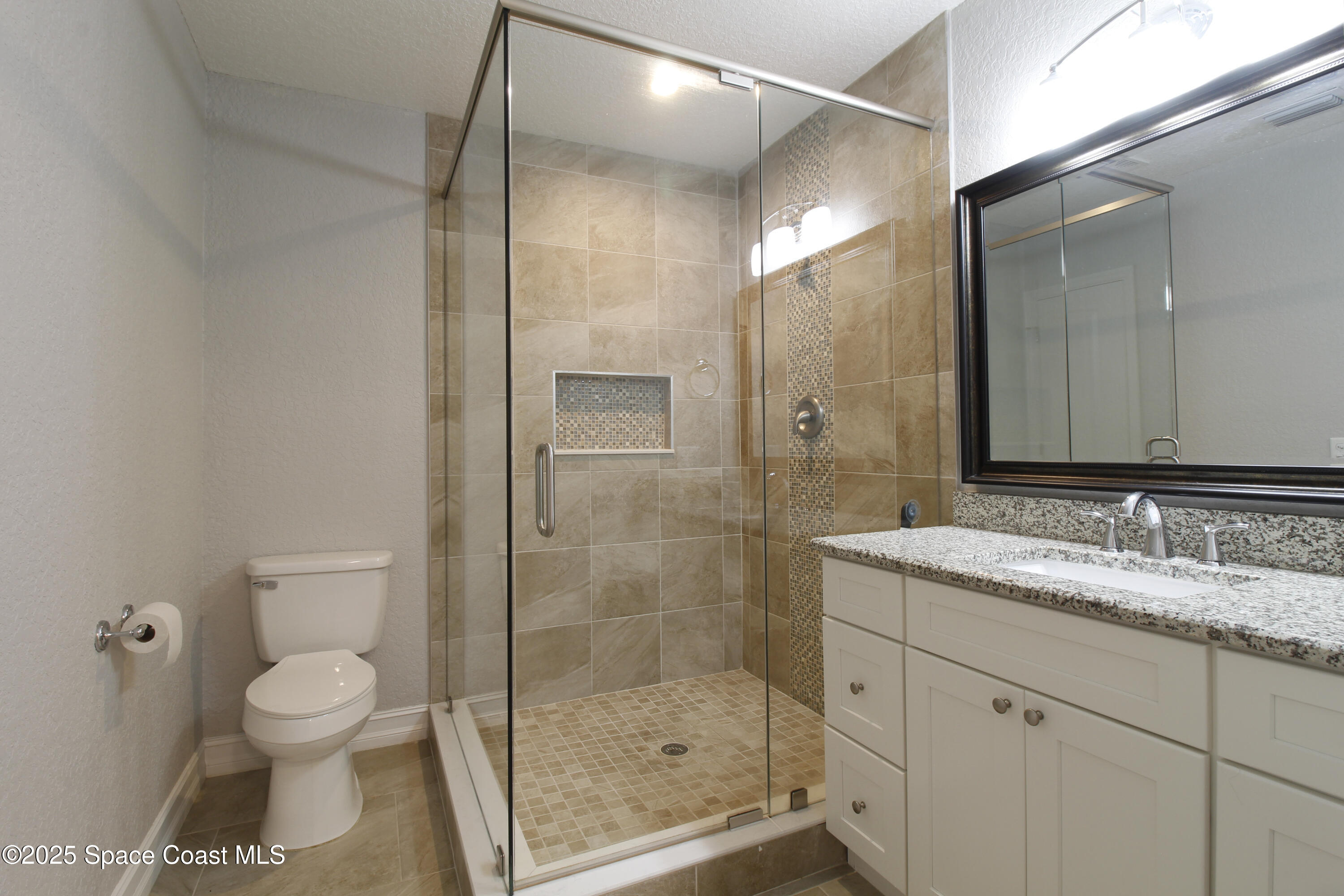 827 Glenmore Circle Melbourne, FL 32901 - Photo 21 of 30 a bathroom with a granite countertop sink a toilet and shower