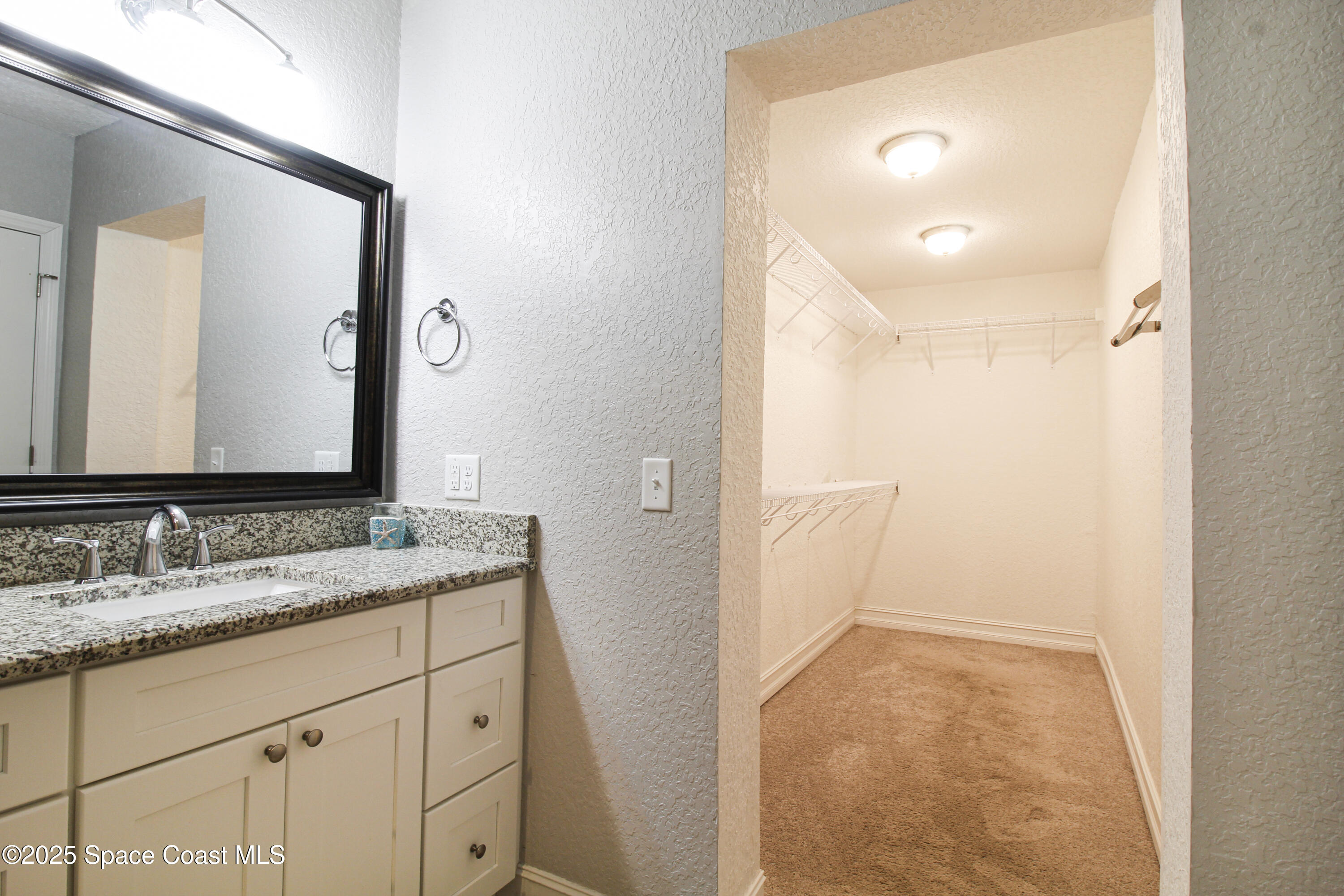 827 Glenmore Circle Melbourne, FL 32901 - Photo 22 of 30 a bathroom with a granite countertop sink and a mirror