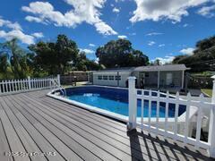 827 Glenmore Circle Melbourne, FL 32901 - Photo 26 of 30 a view of a patio with dining table and chairs with wooden floor