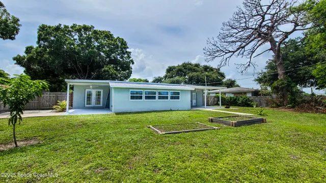 a view of a house with backyard and sitting area
