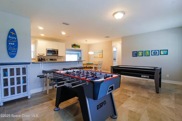 a room with furniture pool table and windows