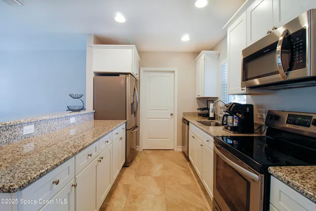 a large kitchen with stainless steel appliances granite countertop a sink and a stove