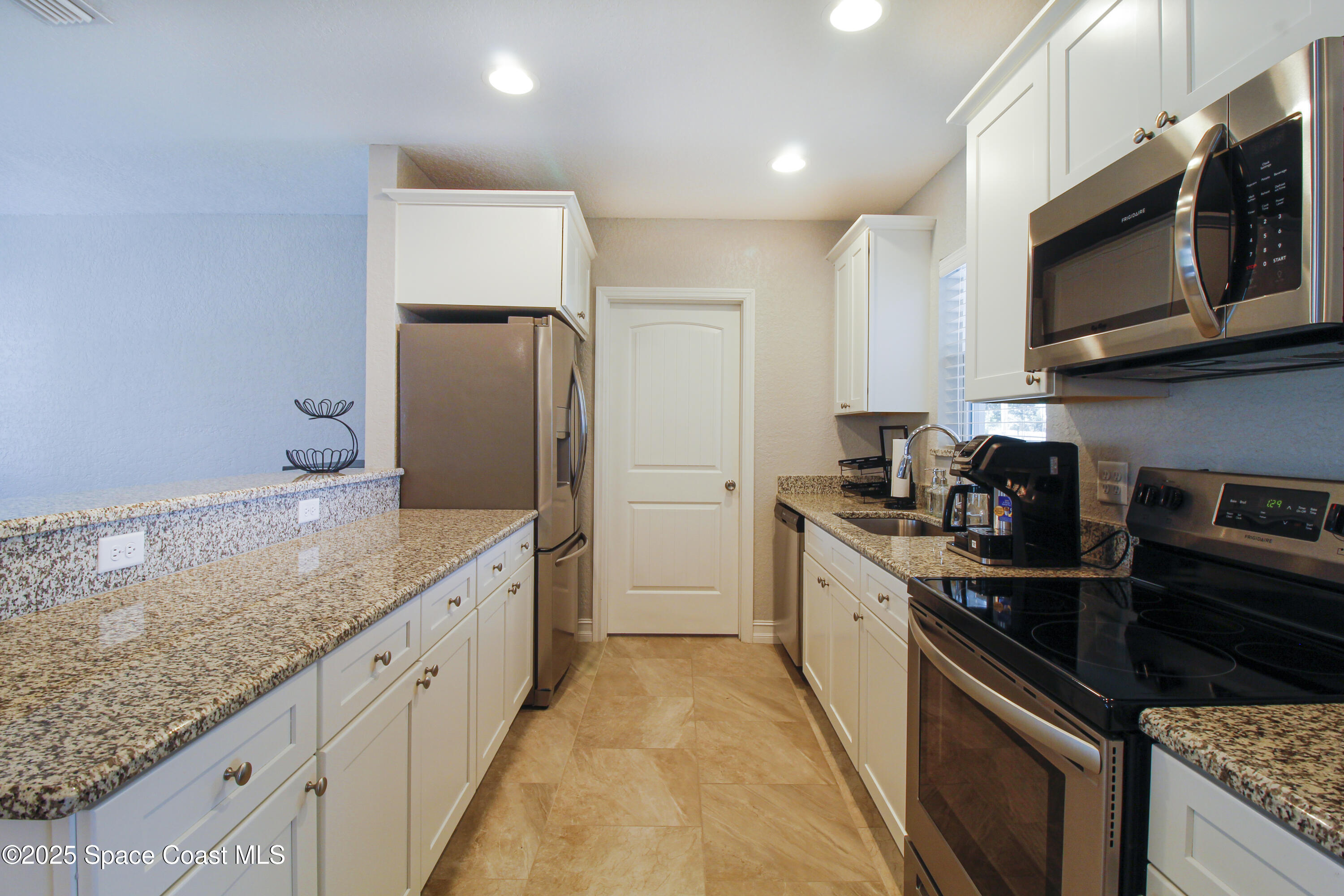 827 Glenmore Circle Melbourne, FL 32901 - Photo 5 of 30 a large kitchen with stainless steel appliances granite countertop a sink and a stove