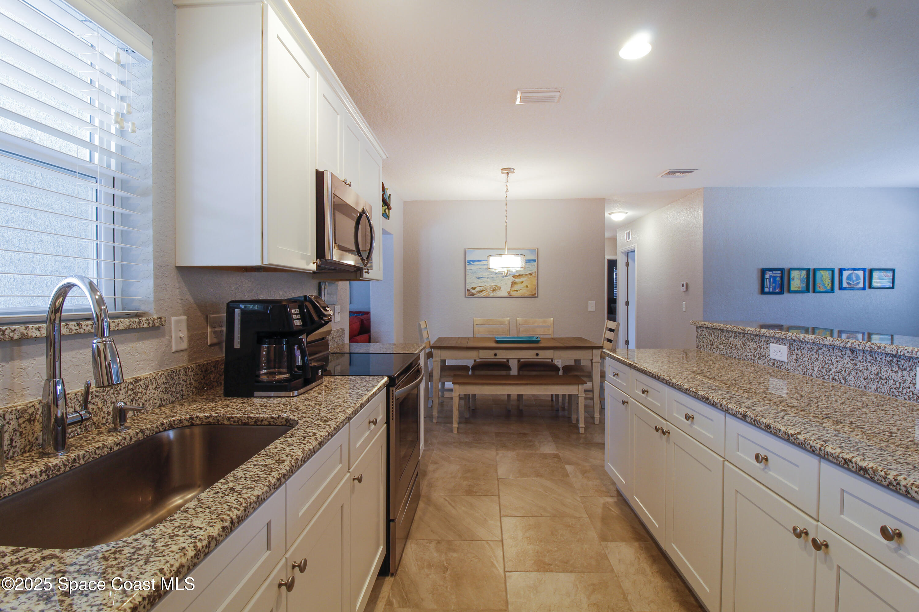 827 Glenmore Circle Melbourne, FL 32901 - Photo 7 of 30 a kitchen with a stove sink and cabinets