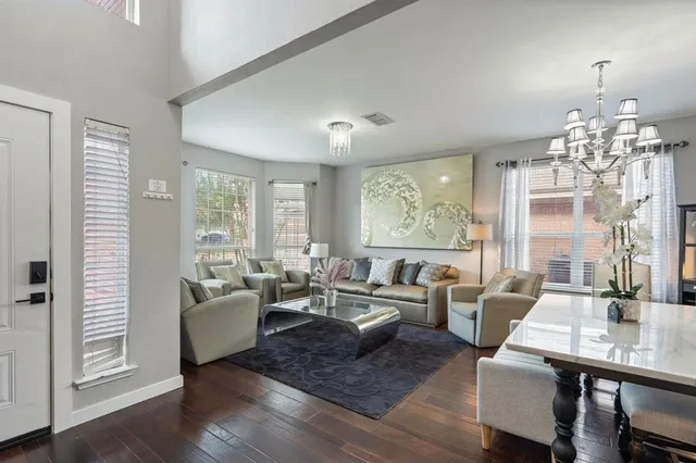 a living room with fireplace furniture and a chandelier