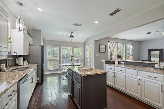 a large kitchen with kitchen island a sink stainless steel appliances and a large window