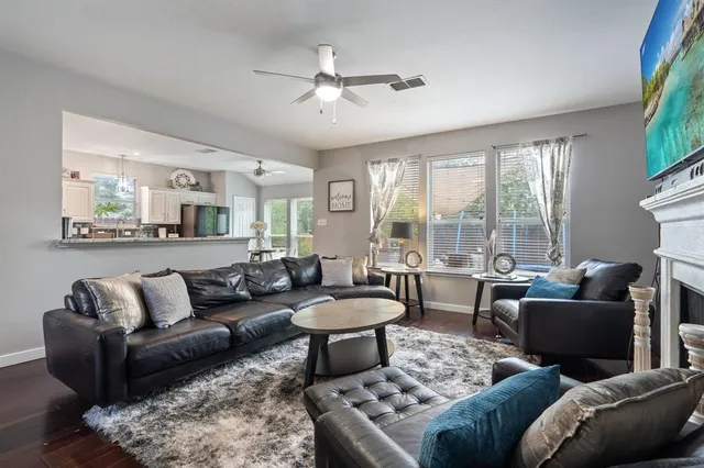 a living room with furniture a flat screen tv and a fireplace