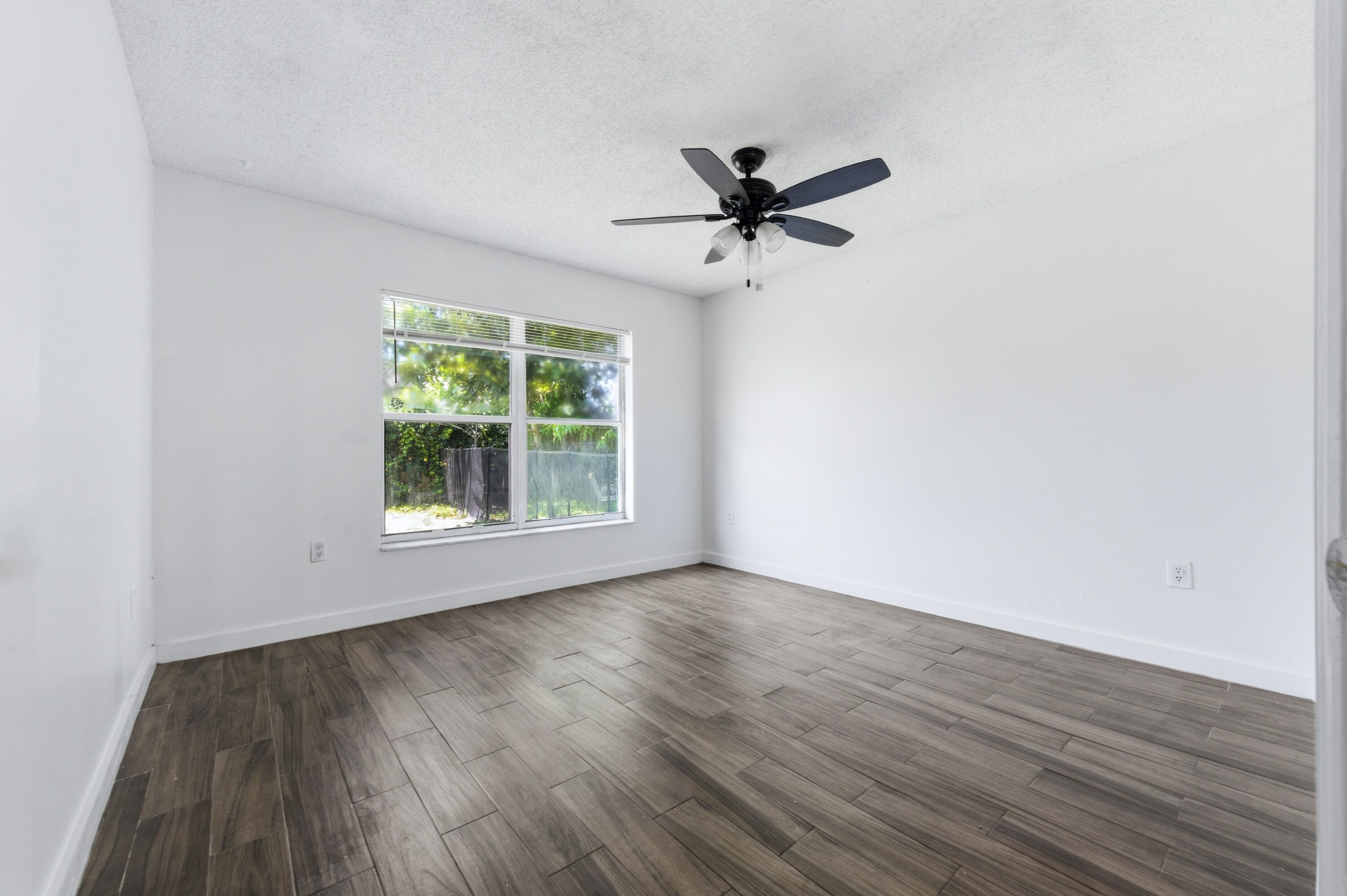 6088 Heather Street Jupiter, FL 33458 - Photo 11 of 18 a view of empty room with wooden floor and fan