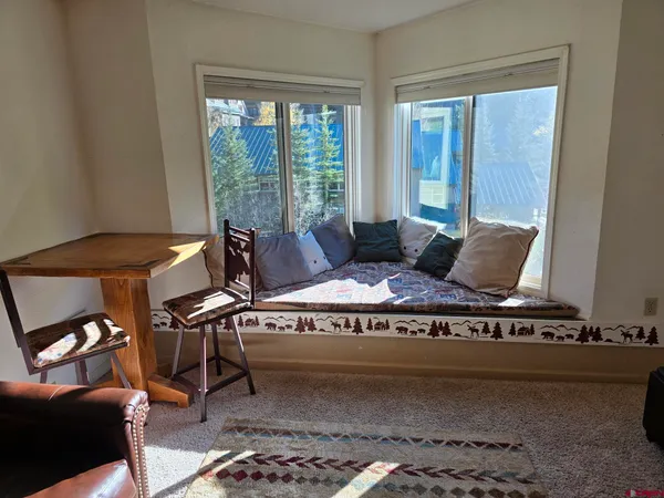 a living room with furniture and a floor to ceiling window