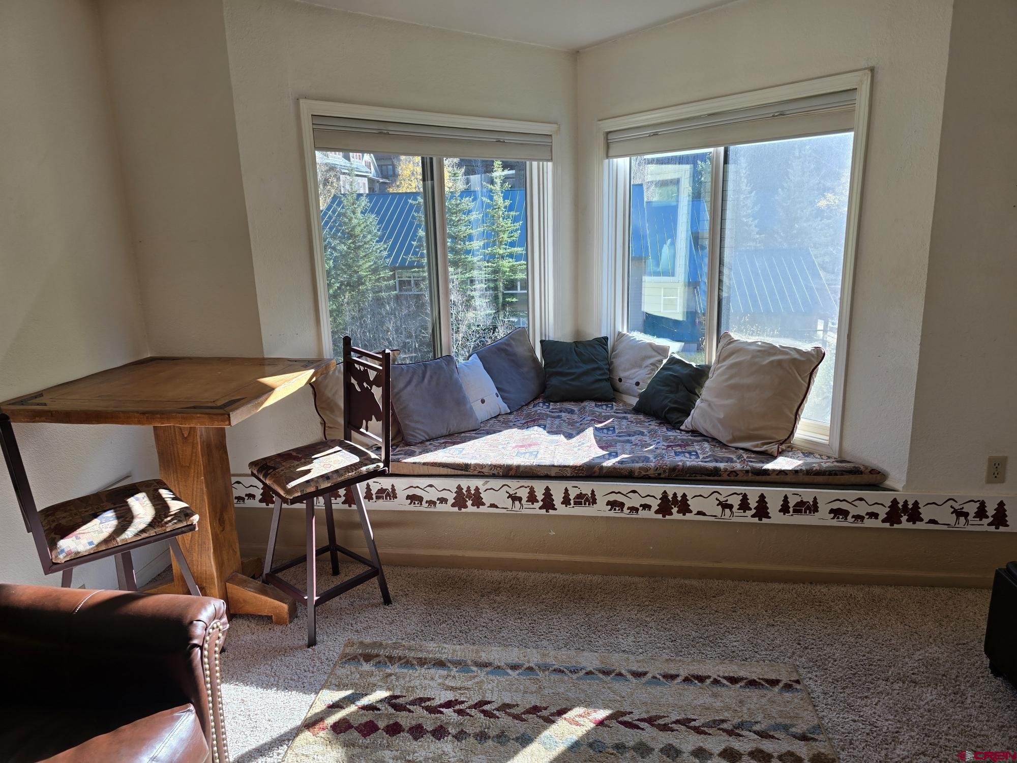 a living room with furniture and a floor to ceiling window