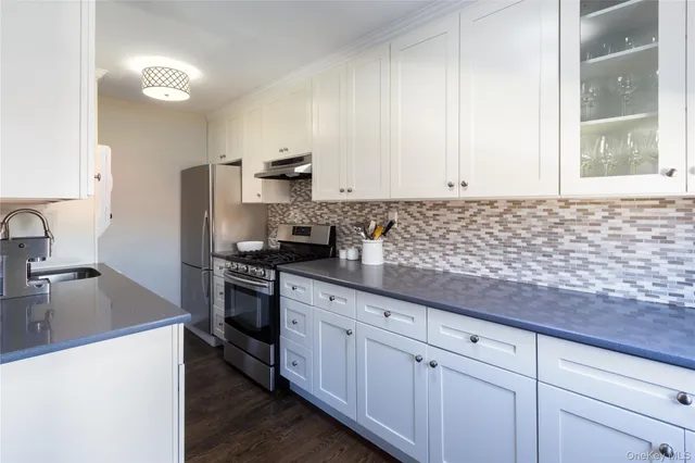 a kitchen with granite countertop a sink stainless steel appliances and cabinets