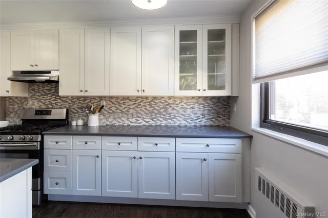 a kitchen with granite countertop white cabinets and sink