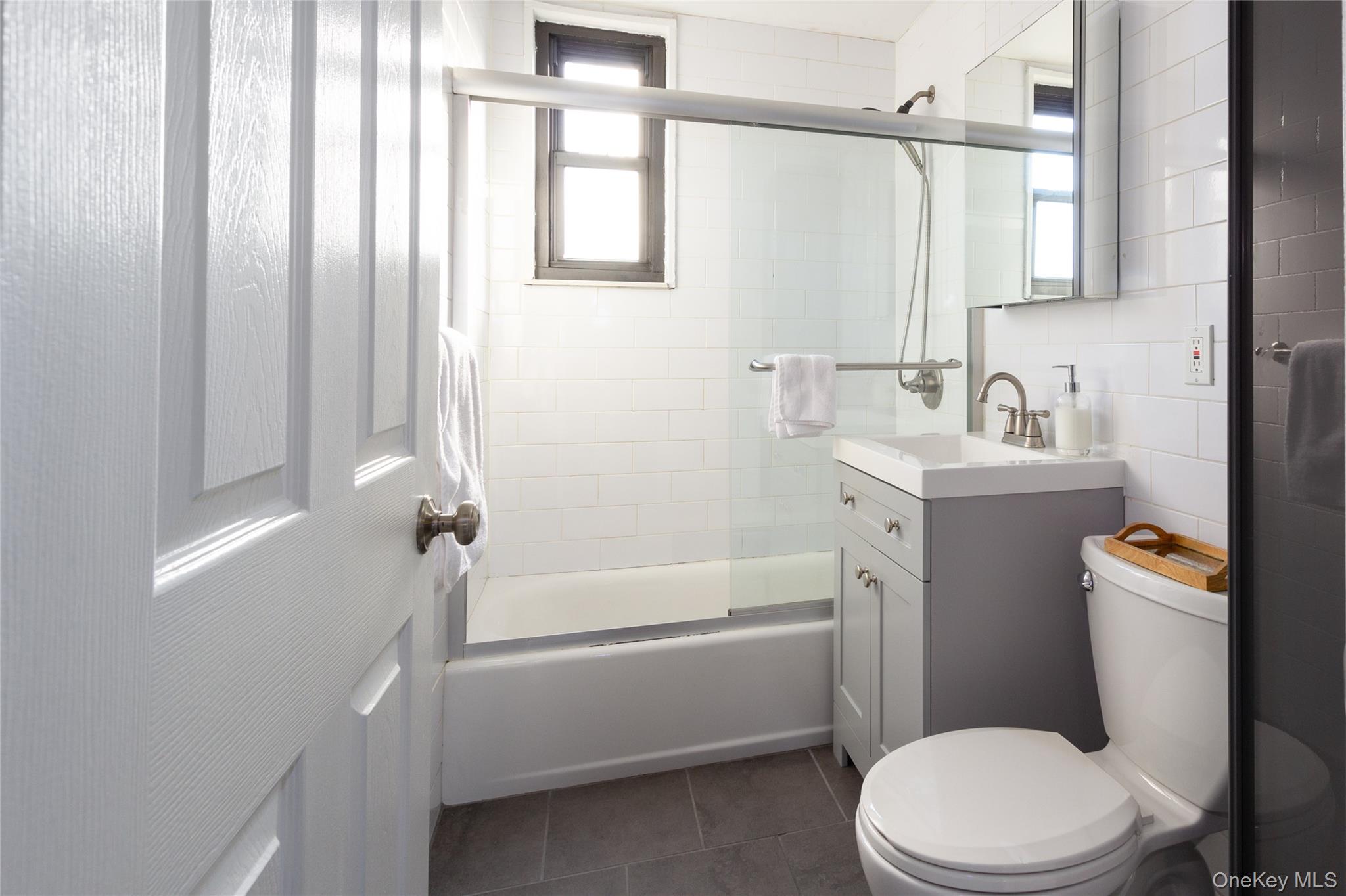 163-62 Willets Point Boulevard, Unit UPPR Queens, NY 11357 - Photo 18 of 19 a bathroom with a sink a toilet a mirror and shower