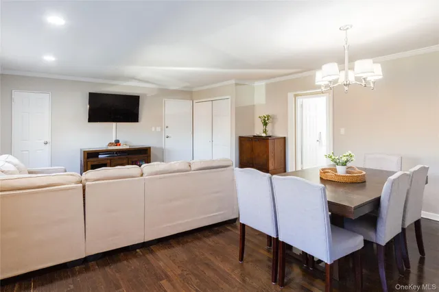 a living room with furniture a flat screen tv and a dining table