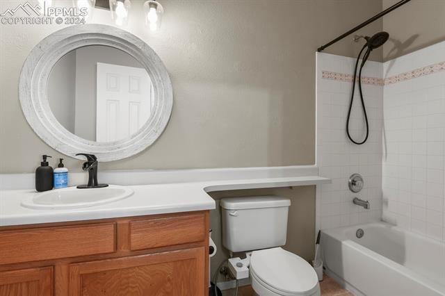 8036 Ferguson Road Peyton, CO 80831 - Photo 18 of 29 Full bathroom with tile floors, vanity, tiled shower / bath combo, and toilet