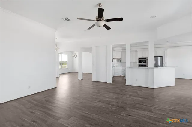 a view of a kitchen with wooden floor and a ceiling fan