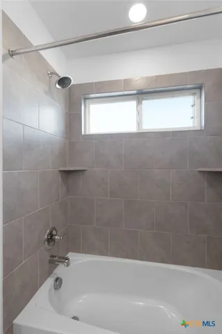 a bathroom with a bathtub and a shower
