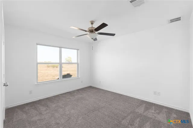 an empty room with a window and a fan