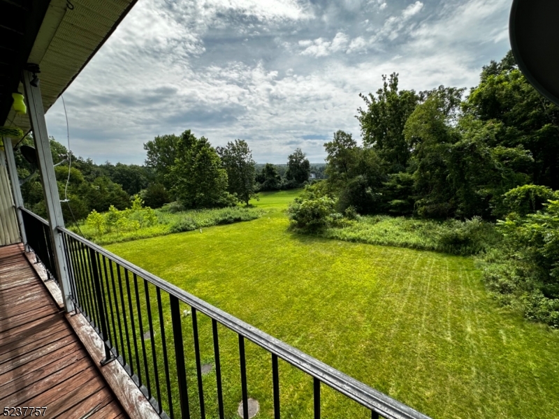 a view of a balcony with yard