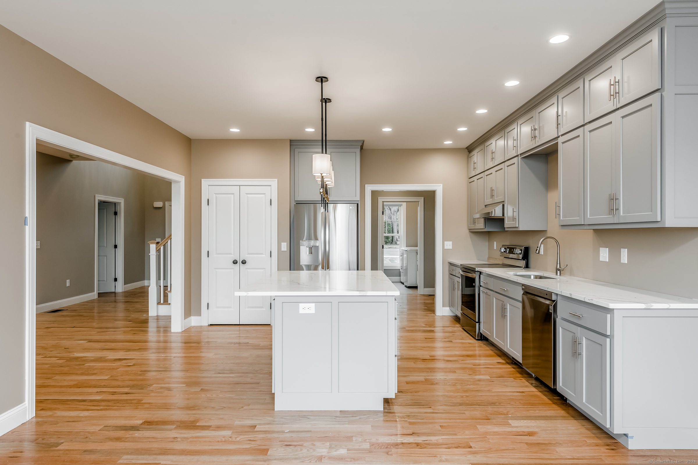 a large kitchen with stainless steel appliances granite countertop a large center island and a sink