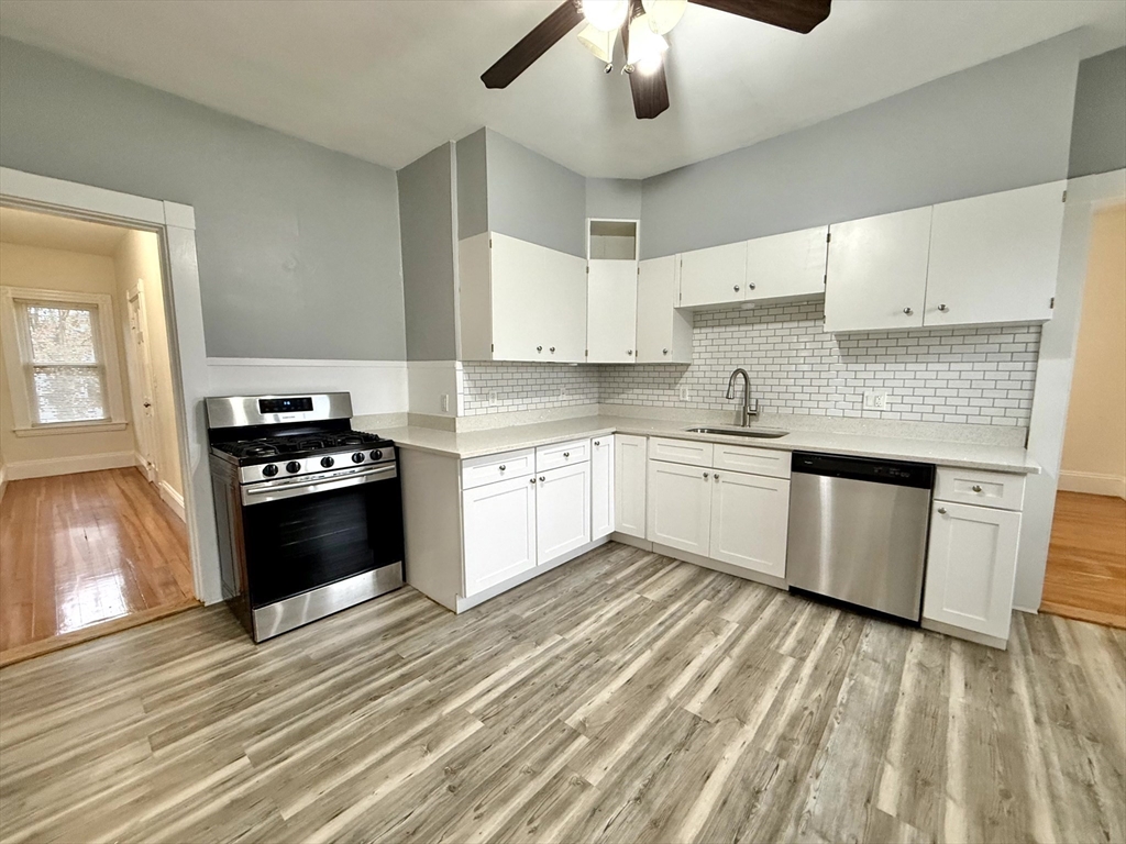 a kitchen with a stove cabinets and wooden floor