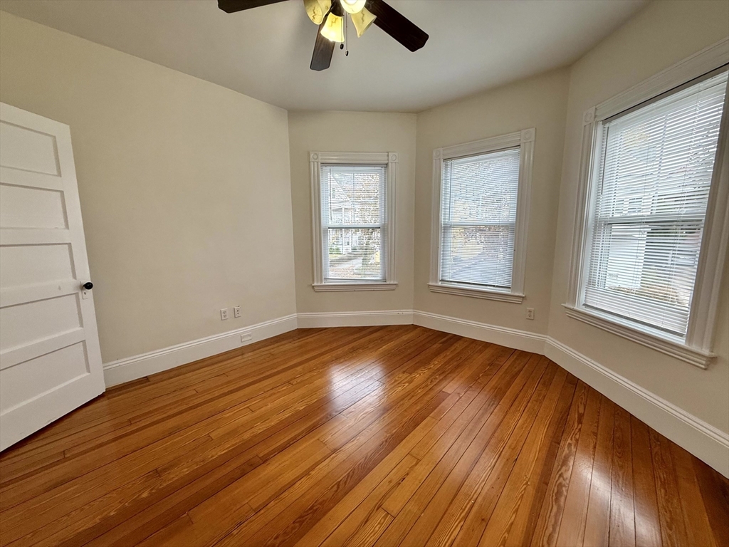 23 Park Road, Unit 23 Belmont, MA 02478 - Photo 18 of 21 an empty room with wooden floor chandelier fan and windows