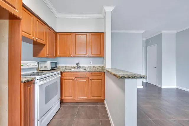 a kitchen with stainless steel appliances granite countertop a stove a sink and a refrigerator