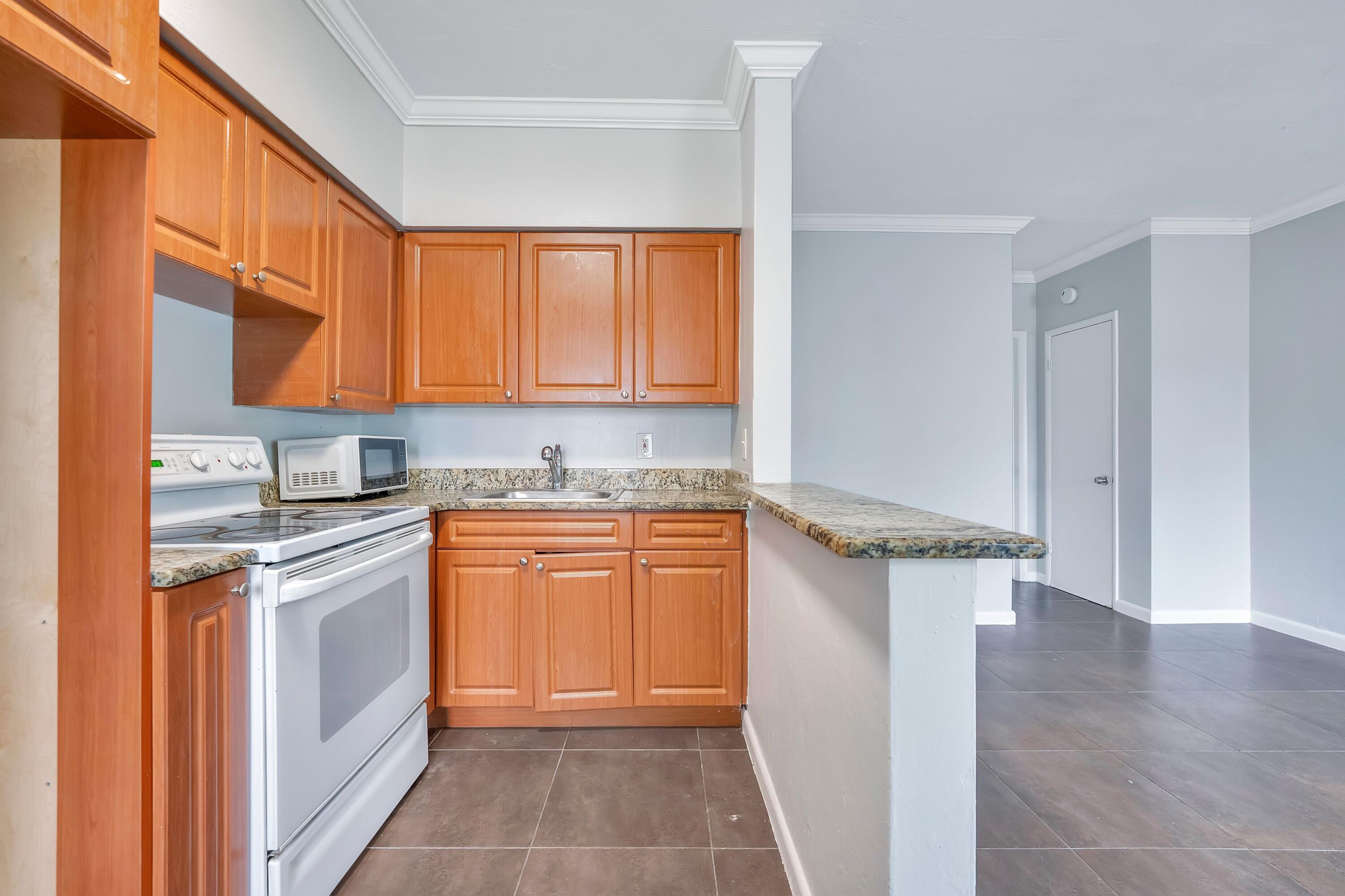 521 Northeast 82nd Terrace, Unit 9 Miami, FL 33138 - Photo 6 of 11 a kitchen with stainless steel appliances granite countertop a stove a sink and a refrigerator