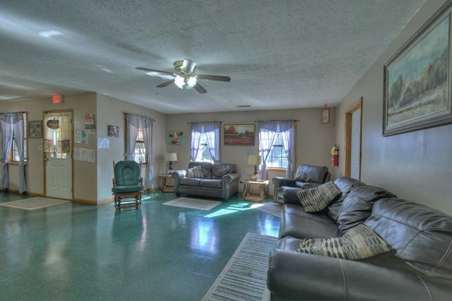 a living room with furniture a flat screen tv and a dining table