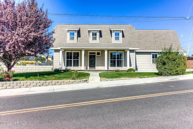 a front view of a house with a garden and plants