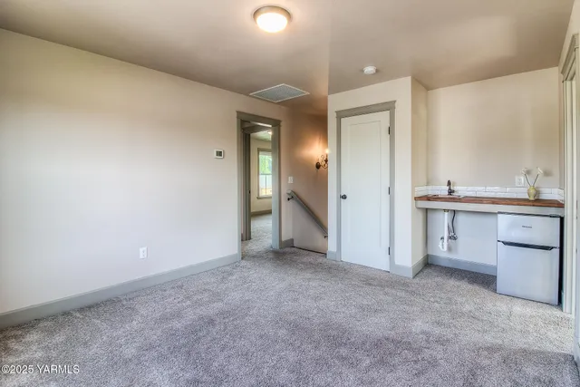 an empty room with a bathroom and sink