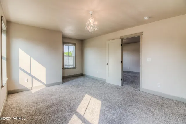 an empty room with windows and ceiling fan